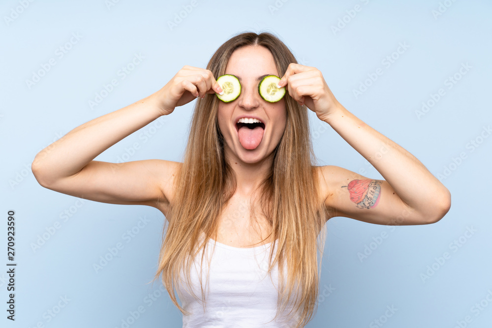Beautiful young woman holding slices of cucumber Beautiful young woman holding slices of cucumber