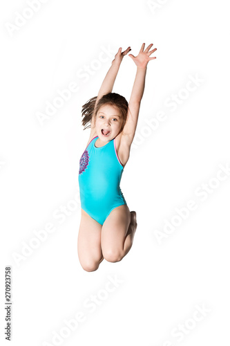 Little caucasian female 7 years old girl in cyan swimming costume jumping on white background.