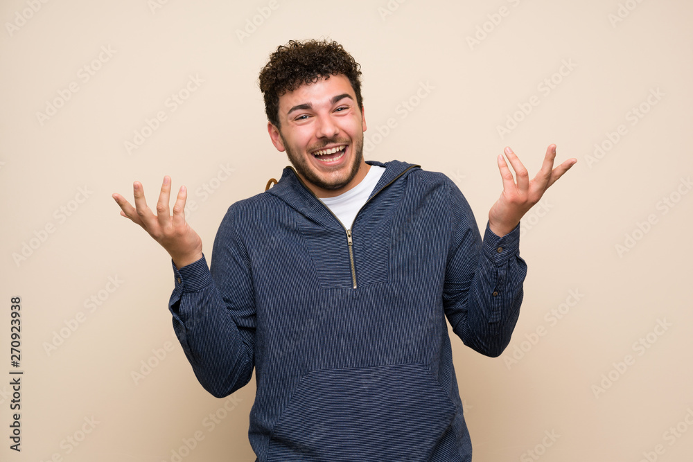 Man with curly hair over isolated wall smiling a lot Man with curly hair over isolated wall smiling a lot