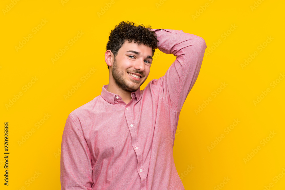 Man with curly hair over isolated yellow wall laughing Man with curly hair over isolated yellow wall laughing