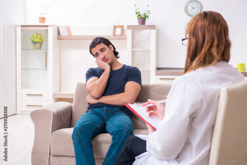 Young male patient discussing with female psychologist personal Young male patient discussing with female psychologist personal