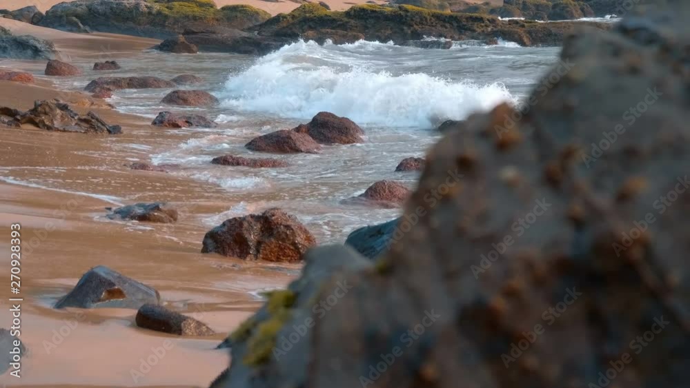 Ocean waves roll on a wild beach, breaking on the cobblestones, Goa, India. Shot in motion Ocean waves roll on a wild beach, breaking on the cobblestones, Goa, India. Shot in motion