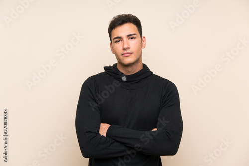 Handsome man over isolated background keeping arms crossed