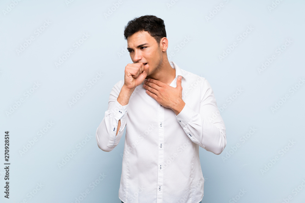 Handsome man over blue wall is suffering with cough and feeling bad Handsome man over blue wall is suffering with cough and feeling bad