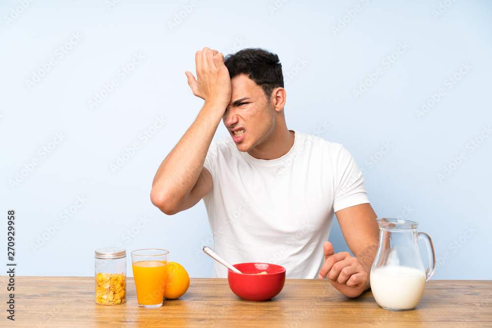 Handsome man in having breakfast having doubts with confuse face expression Handsome man in having breakfast having doubts with confuse face expression