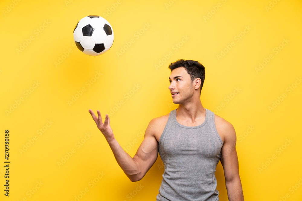 Handsome sport man over isolated background with a soccer ball
