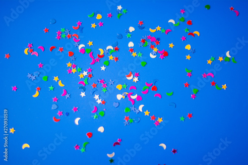 Festive party confetti on a bright colorful blue background