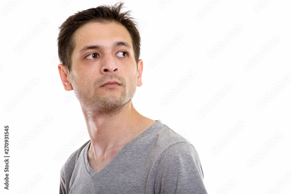 Studio shot of young man looking back while thinking