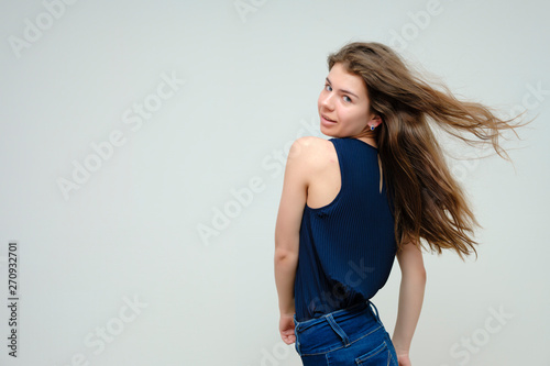 Photo portrait of a beautiful sexy brunette woman girl, smiling and pleased with life, with long flowing dark hair on a white background.