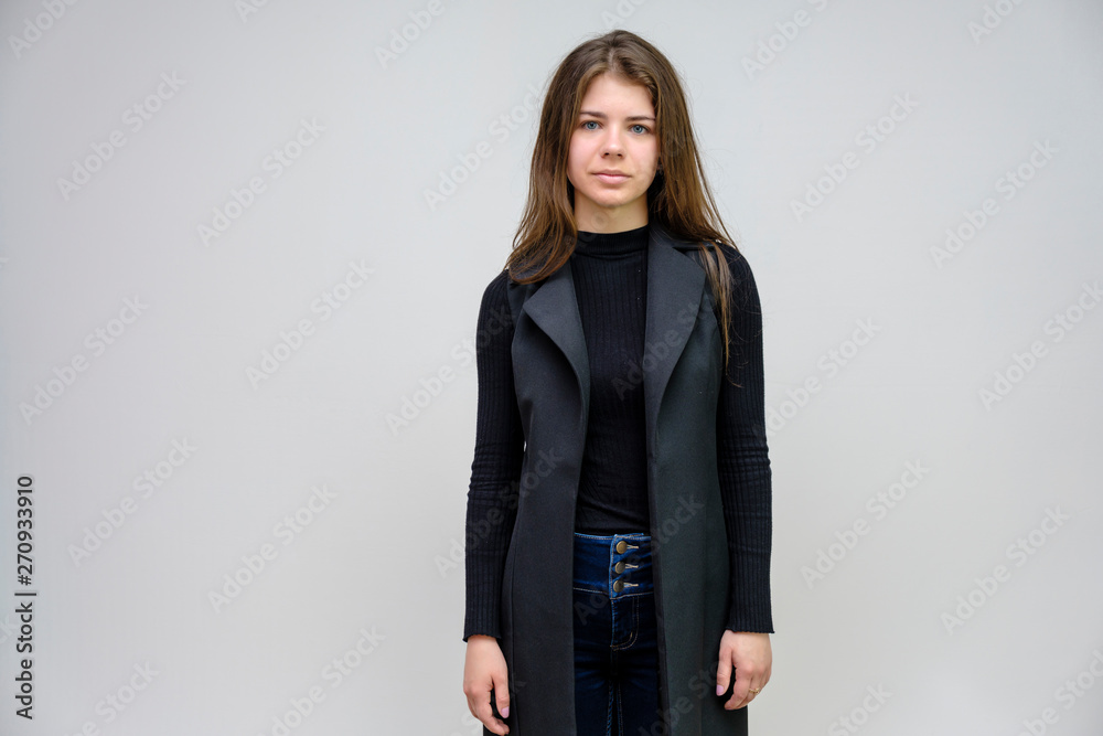 Photo portrait of a beautiful smiling brunette business woman on a white background in a black business suit with long beautiful dark hair in the studio. Photo portrait of a beautiful smiling brunette business woman on a white background in a black business suit with long beautiful dark hair in the studio.