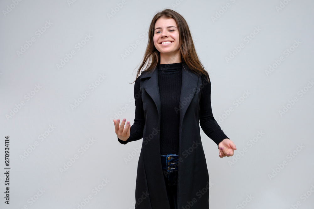 Photo portrait of a beautiful smiling brunette business woman on a white background in a black business suit with long beautiful dark hair in the studio.