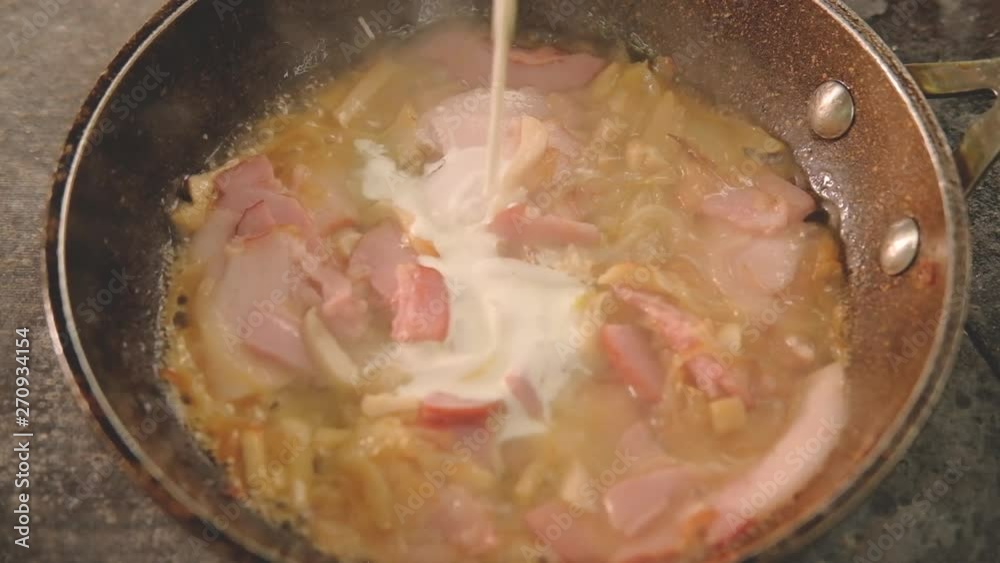 Food cooking recipe. Meal ingredients in pan. Chef adding dairy cream to simmering ham bacon onions and squid Food cooking recipe. Meal ingredients in pan. Chef adding dairy cream to simmering ham bacon onions and squid