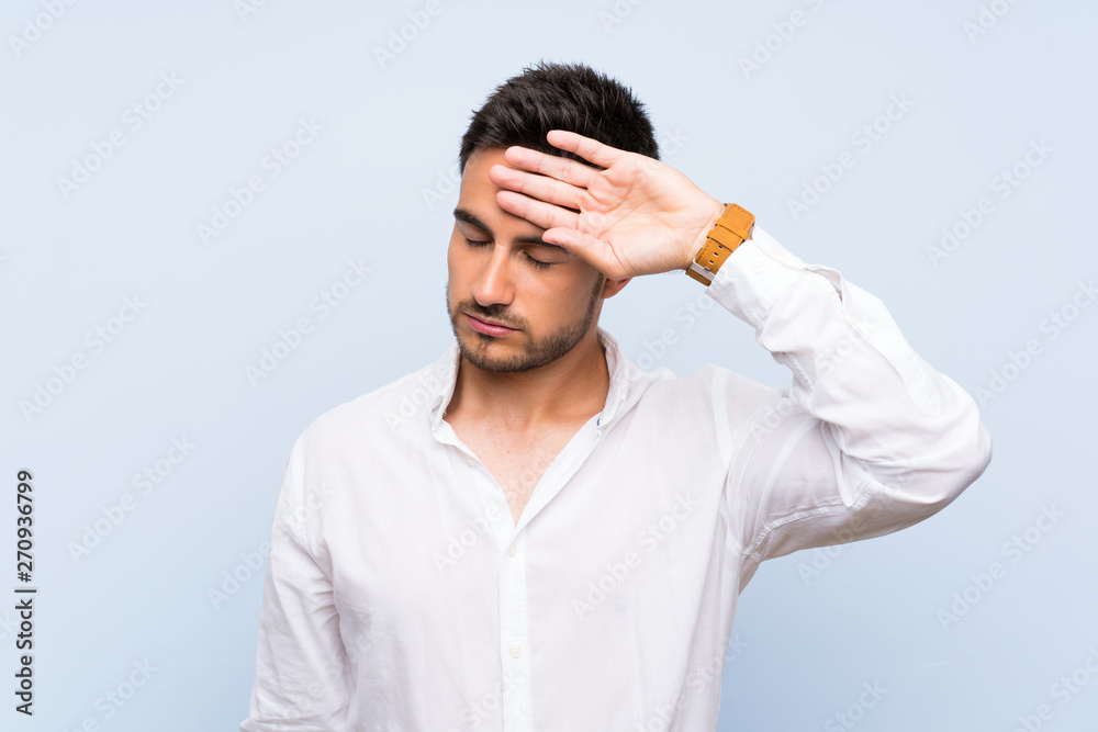 Handsome young man over isolated blue background with tired and sick expression Handsome young man over isolated blue background with tired and sick expression