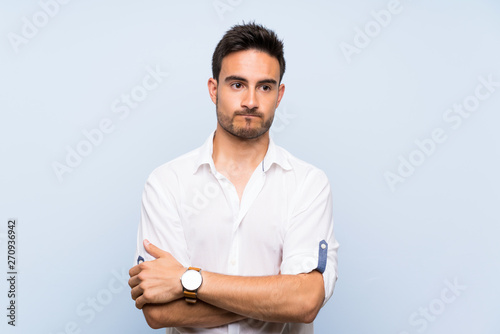 Handsome young man over isolated blue background feeling upset