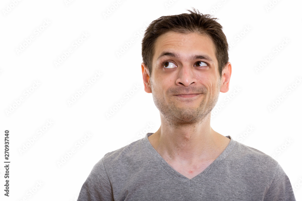 Studio shot of young man thinking while looking up Studio shot of young man thinking while looking up