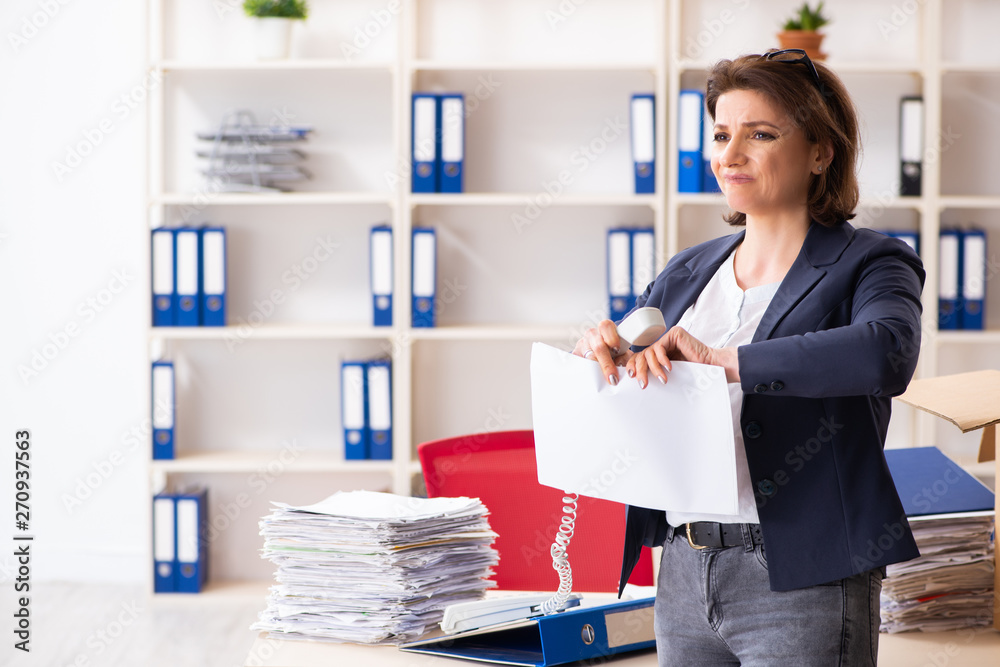 Middle-aged female employee being fired from her work Middle-aged female employee being fired from her work