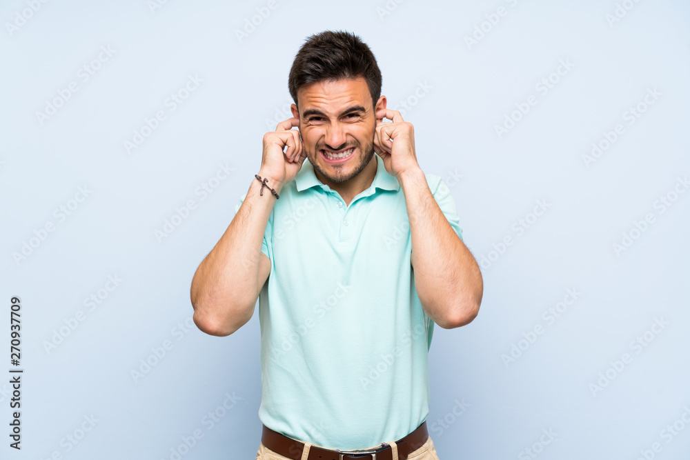 Handsome young man over isolated background frustrated and covering ears Handsome young man over isolated background frustrated and covering ears