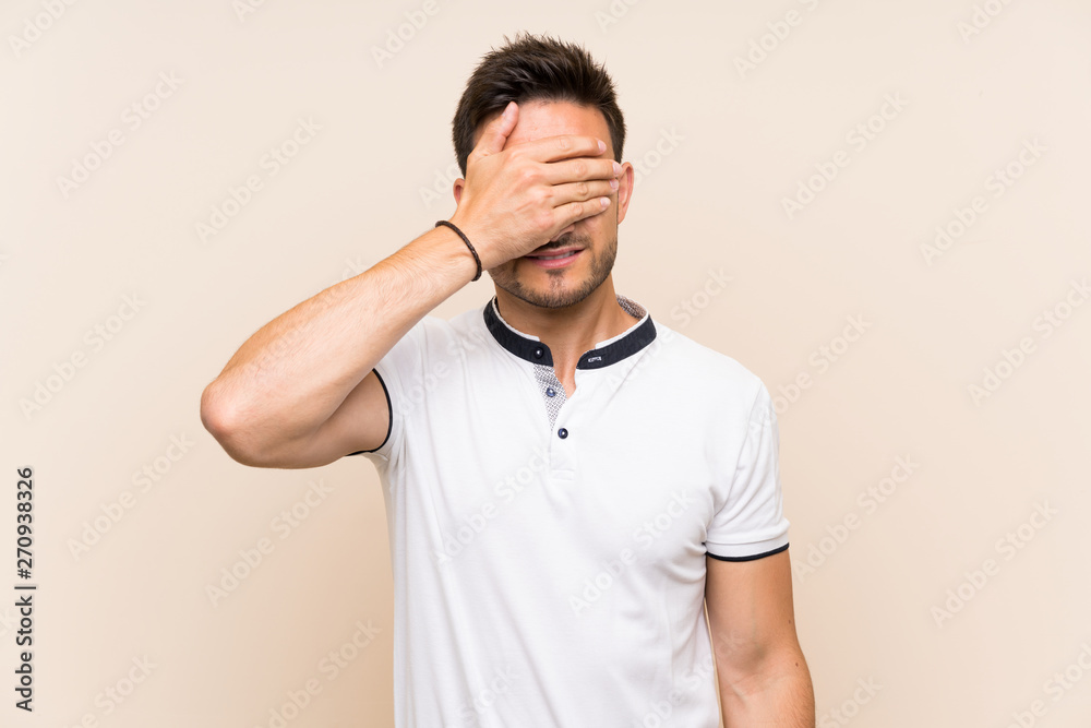 Handsome young man over isolated background covering eyes by hands. Do not want to see something Handsome young man over isolated background covering eyes by hands. Do not want to see something