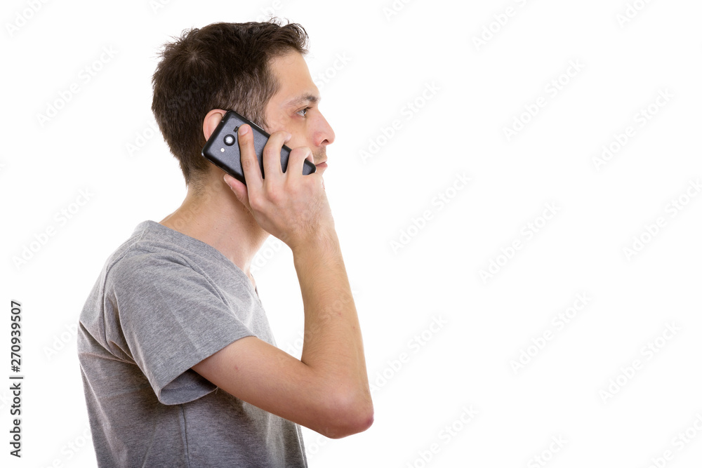 Profile view of young man talking on mobile phone Profile view of young man talking on mobile phone