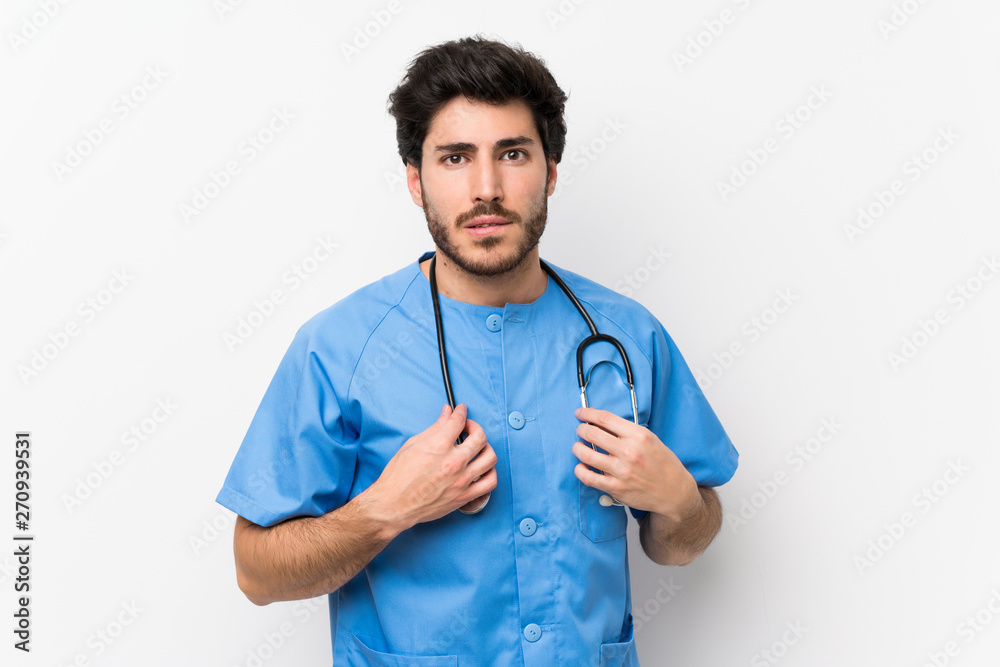 Surgeon doctor man over isolated white wall having doubts and with confuse face expression Surgeon doctor man over isolated white wall having doubts and with confuse face expression