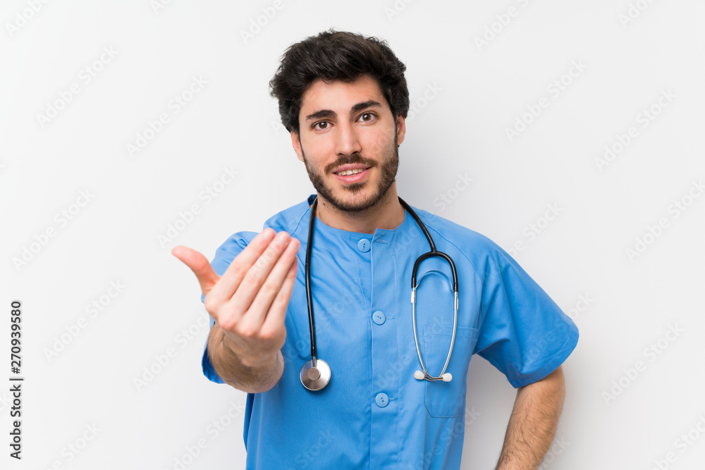 Surgeon doctor man over isolated white wall inviting to come Surgeon doctor man over isolated white wall inviting to come