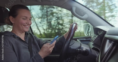Wallpaper Mural Woman gets into an accident on the car.  Dangerous situation on the road. Woman drives the car and typing text on the smartphone. Adult Woman in the car using mobile phone while driving. Real time. Torontodigital.ca
