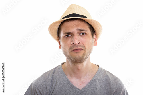 Studio shot of sad young man wearing hat