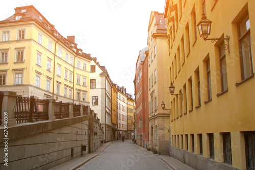 Deserted pedestrian street in the old part of Stockholm, Sweden. Colorful houses with vintage lanterns. © Irina Kulikova