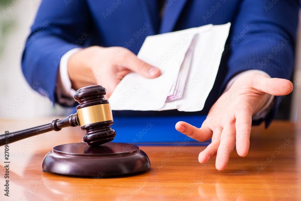 Young male judge sitting in courtroom Young male judge sitting in courtroom