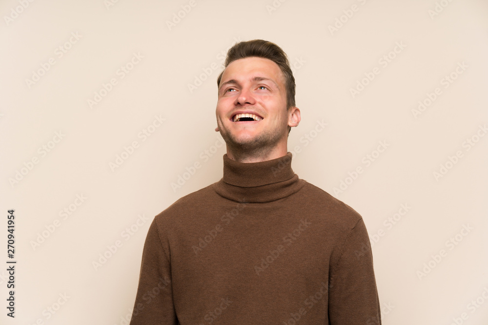 Blonde handsome man over isolated wall laughing Blonde handsome man over isolated wall laughing