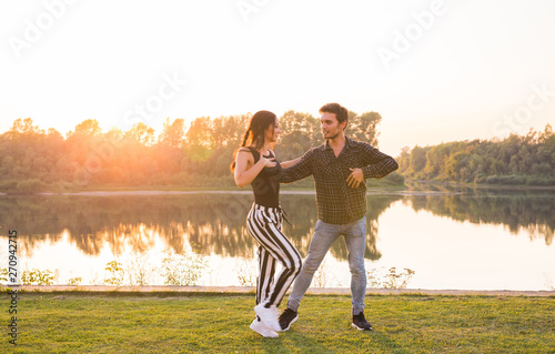 Kizomba, bachata, zouk and latin social dance concept - Man and woman dancing over nature background photo