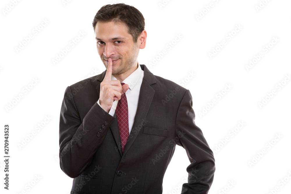 Studio shot of happy young businessman smiling with finger on li Studio shot of happy young businessman smiling with finger on li