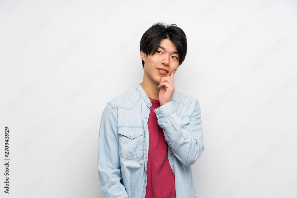 Asian man on isolated white background thinking an idea while looking up Asian man on isolated white background thinking an idea while looking up