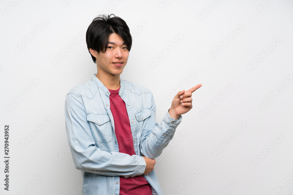 Asian man on isolated white background pointing finger to the side Asian man on isolated white background pointing finger to the side