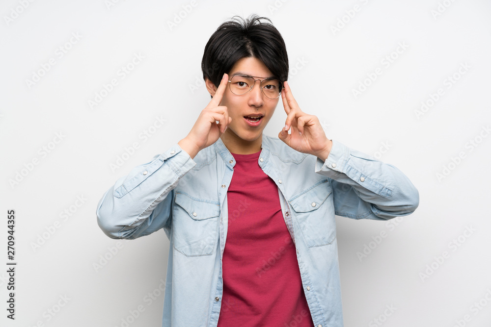 Asian man on isolated white background with glasses and surprised Asian man on isolated white background with glasses and surprised