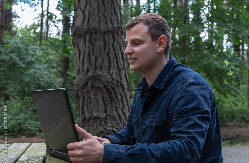 man work on computer in the fresh air in forest man work on computer in the fresh air in forest