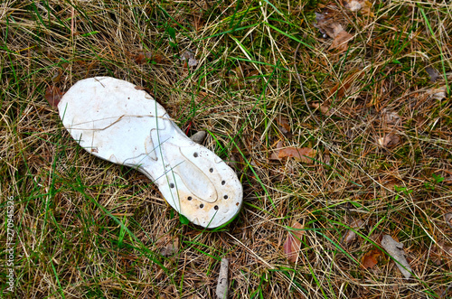 Old abandoned boot in the forest, shoe sole. Concept of direction, route, location, incident, loss, disappearance of a person or a committed crime