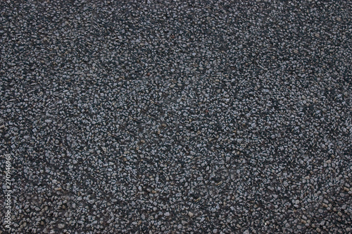 Asphalt roadway with a rough dark surface .Texture or background.