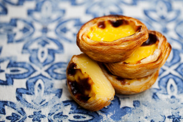 Egg tart, traditional Portuguese dessert, pastel de nata. Blue background. Close up.