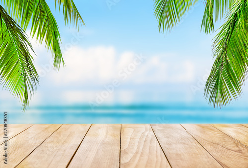 Wooden table top on blue sea and white sand beach