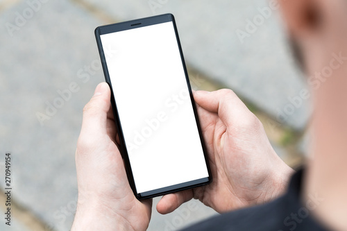 Man uses his Mobile Phone outdoor, close up.