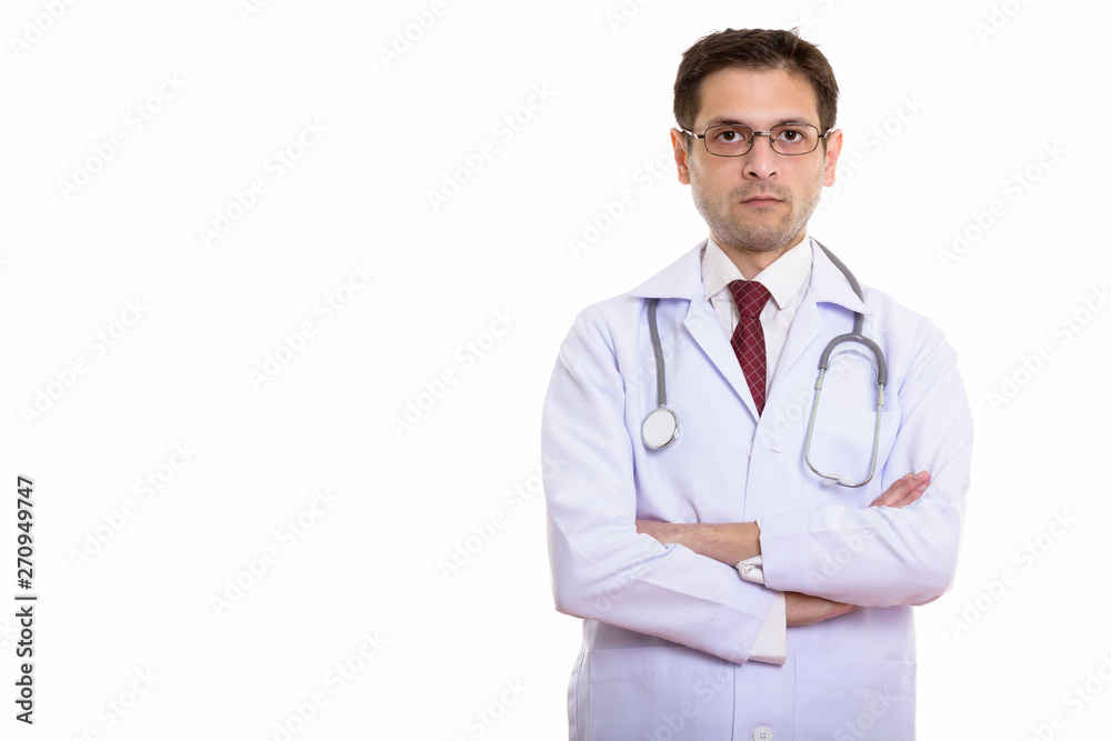 Studio shot of young man doctor wearing eyeglasses with arms cro Studio shot of young man doctor wearing eyeglasses with arms cro
