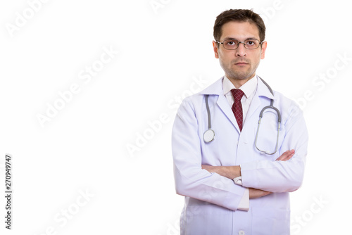 Studio shot of young man doctor wearing eyeglasses with arms cro