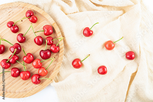 Wooden plate filled with fresh red cherries still life