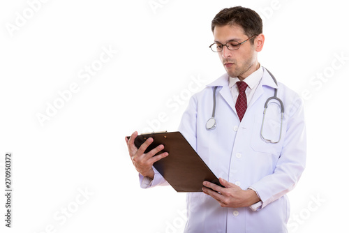 Studio shot of young man doctor reading on clipboard
