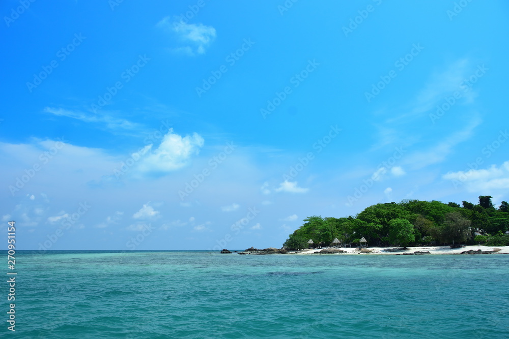 The small island has white beaches. Clear water and blue sky The small island has white beaches. Clear water and blue sky