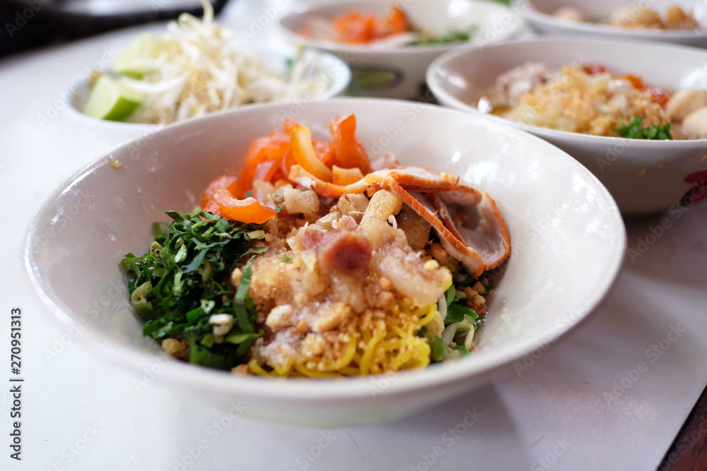 Thai dry noodle tom yum (Kuay Tiew Thai) with minced pork, red pork, pork ball.