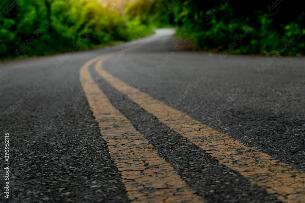 Asphalt road with two yellow lines in the middle on the curve to the ...