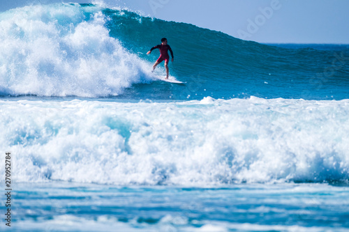 teenager surfing at the wave in tenerife playa de las americas - red wetsuits and beautiful and perfect wave © Daniel