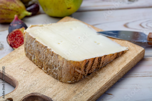 Piece of French cheese Tomme de Brebis made from sheep milk served as dessert with fresh figs and pears photo